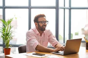 Executive smiling while working on his laptop	