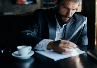 business man sitting at a table in a cafe documents work official coffee cup 