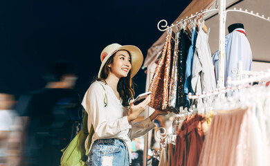 Young adult woman shopping at outdoor night market