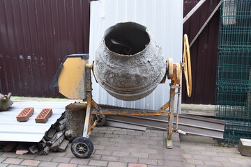 Concrete mixer on backyard landscape or building site private territory. Local construction business