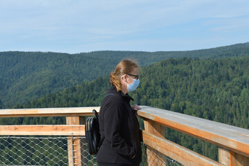 Portrait of a woman's head on a tourist tower in the background with nature and forests