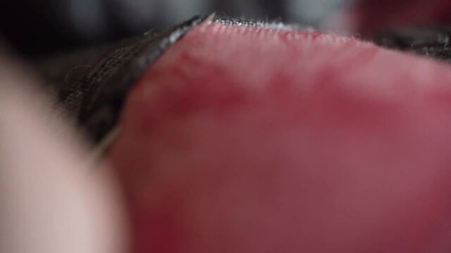 grandmother is sewing a patchwork quilt with silk thread. Close-up, macro shot