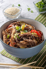 Wok with soba noodles. Buckwheat soba noodles in a grey Cup with chopsticks. Soba noodles with chicken, celery and red sweet pepper.