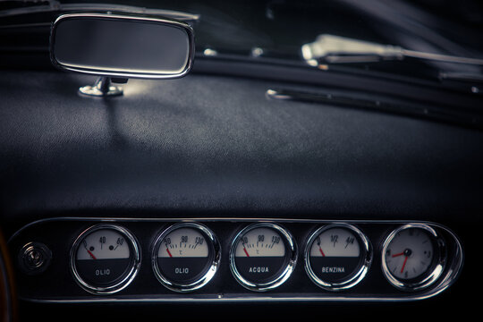 Tachometer, clock and various gauges on a vintage car's dashboard