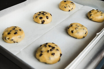 Raw chocolate chip cookies on the tray ready to bake - traditional American dessert