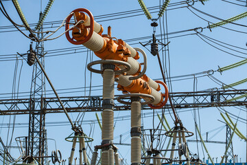 Electric switcher and glass insulators on blue sky background. High-voltage equipment. Electrical...