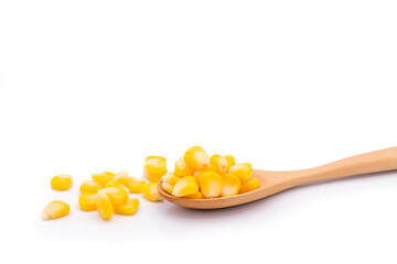 Delicious sweet yellow ripe corn kernels are placed in a wooden spoon and placed on the ground. White background