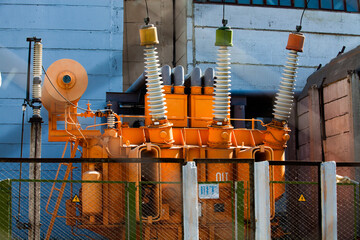 Power generating plant. Orange power transformer on electrical substation. High-voltage equipment