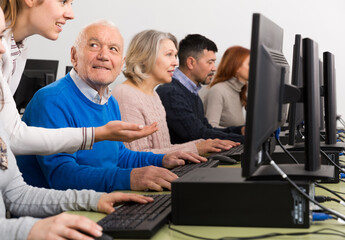 Portrait of smiling senior man during computer classes for elderly people at university of third age