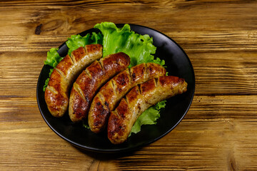 Tasty grilled sausages on a wooden table