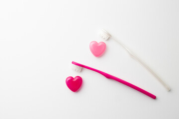ピンクのハート型カプセルと歯ブラシ