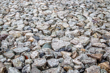 Background of gray stones at a road repair construction site as a drainage layer for paving asphalt