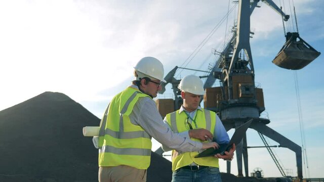 Male engineers are talking about a construction project.