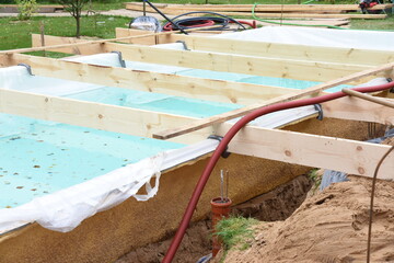 Fiberglass swimming pool construction building. Garden or backyard landscape works for swimming pool installation.