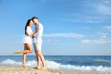Fototapeta na wymiar Happy young couple at beach on sunny day