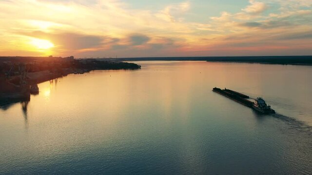 A barge and a coast of a river port at sunset