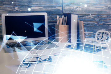 Double exposure of desktop with computer and world map hologram. International data network concept.