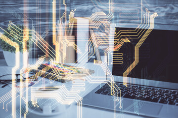 Computer on desktop in office with technology theme hologram. Double exposure. Tech concept.