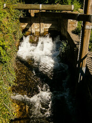 A mill stream with an old lock. You can see the water flowing through it.