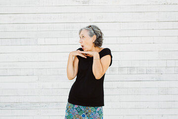 Senior woman making grimace over a white background