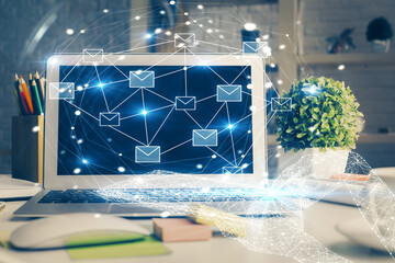 Desktop computer background in office and flying envelops hologram drawing. Double exposure. Electronic mail concept.