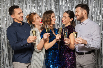 celebration and holidays concept - happy friends toasting champagne glasses at party