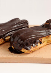 Chocolate eclair on wooden desk food photography. Bekery, cake , choco, pie, confectionary, cream. Three fresh eclairs with chocolate