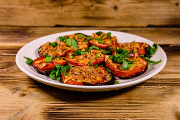 Baked eggplants with tomatoes and cheese in a ceramic plate