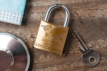 Covid-19 lockdown concept: a lock sorrounded by a key, a stethoscope and a surgical map with the...