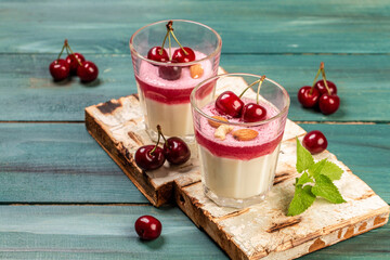 Traditional Italian dessert panna cotta with cherry jelly. Summer yogurt dessert. Food recipe background. Close up