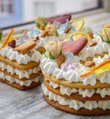 Obraz na płótnie Canvas Creamy fruit cake with white filling with orange chips, dried fruits, decorated with mint