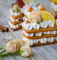 Creamy fruit cake with white filling with orange chips, dried fruits, decorated with mint