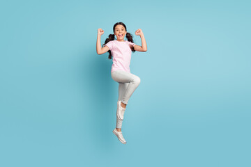 Full length body size view of her she nice attractive lovely cheerful cheery lucky pre-teen girl jumping having fun rejoicing good news victory triumph isolated over blue pastel color background