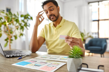 business, remote job and technology concept - male ui designer with laptop computer working on user...