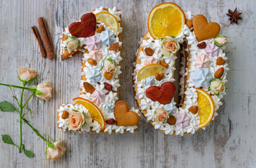 Creamy fruit cake with white filling with orange chips, dried fruits, decorated with mint