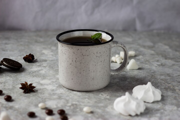 a white mug stands on a white background surrounded by sweets, candies and cookies
