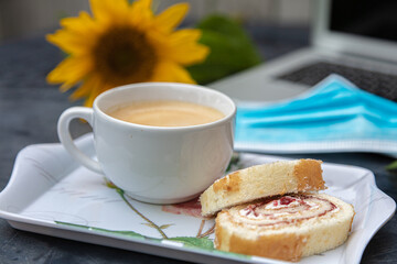 Yellow sunflower flowers and medical mask,  laptop ,cup of coffee and drip on black table, Fall background 2020 concept, protect yourself from coronavirus, pandemic, corantin