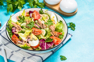 Tuna salad with green leaves, eggs and vegetables.