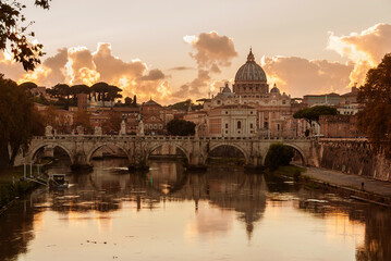 Beautiful sunset view of Rome along River Tiber with the iconic St Peter dome and Holy Angel Bridge