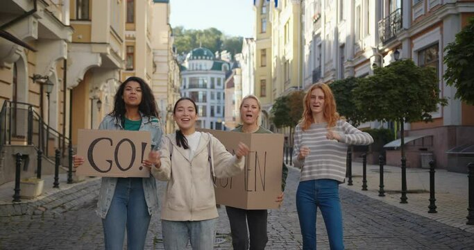 Outdoor portrait of women activists with Go Woman poster