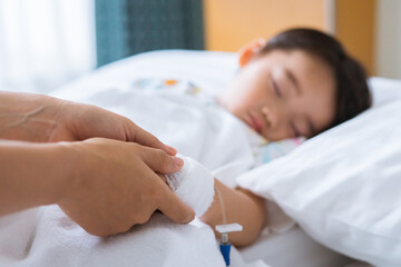 Obraz na płótnie Canvas Hands of mother and sick Asian little boy holding together on sickbed in hospital to give encouragement. Healthcare medical.