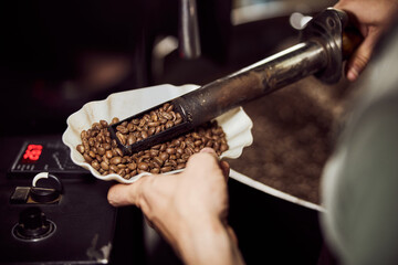 Fototapeta na wymiar Male worker holding bowl of brown coffee beans