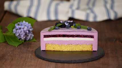 Delicious mousse cake with summer berries and mirror glaze.