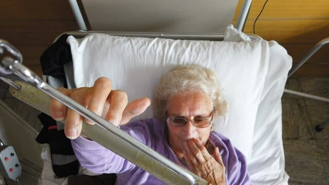 Old sick lady lying in hospital bed