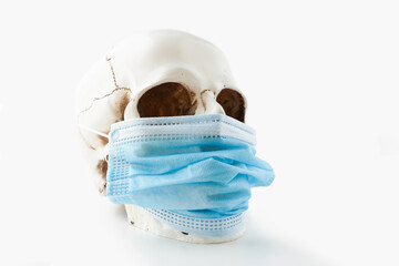 Human skull wearing blue surgical mask on white background, side view