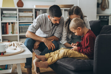 cute young family using tablet together at home