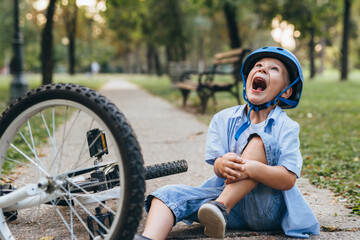 Obraz premium boy crying , fall from the bike outdoors