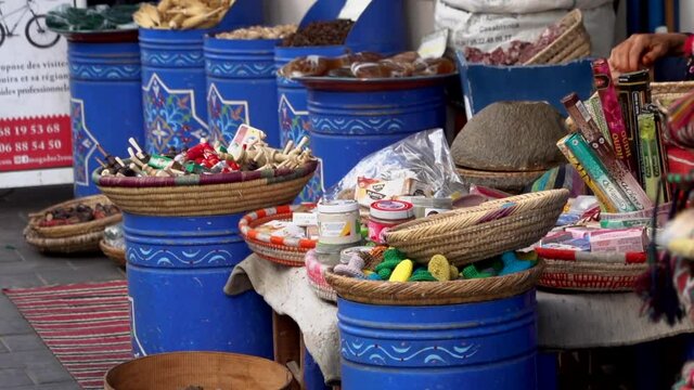 Morocco, Marrakech - October 2019: Argan oil production in a traditional way, Morocco. Close up hand of berber woman produce peanut pasta cracking with stone tool outside on street market 