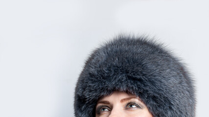 portrait of a woman in fur hat with grey smkey eyes makeup 
