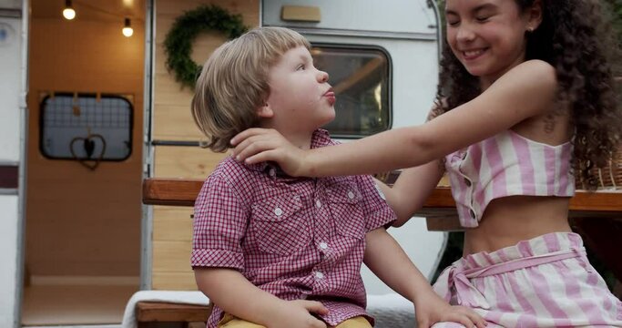 sister and brother having fun and playing together near the trailer house